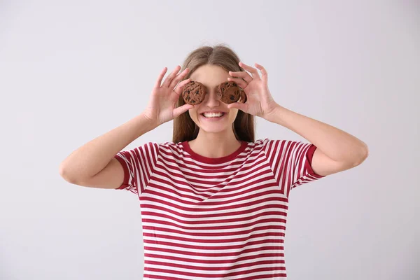 Šťastná mladá žena s chutnými koláčky na pozadí — Stock fotografie