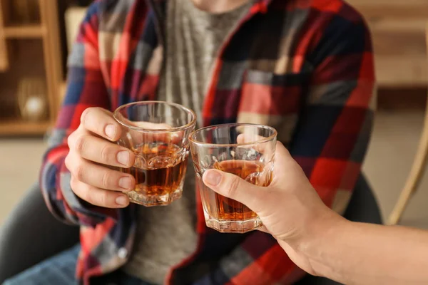Man and woman clinking glasses of cold whisky, closeup — Stock Photo, Image