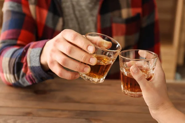 Man and woman clinking glasses of cold whisky, closeup — Stock Photo, Image