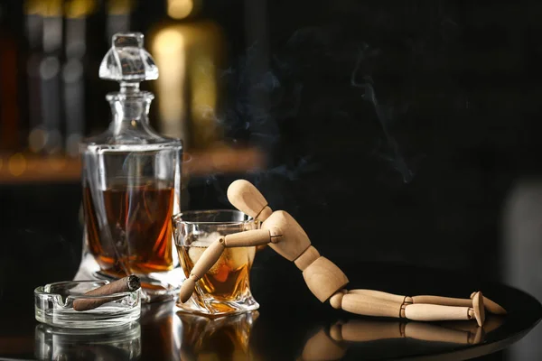Bicchiere e bottiglia di whisky freddo con manichino e sigaro sul tavolo nel bar — Foto Stock