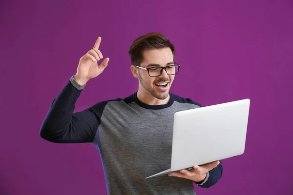 Thoughtful male programmer with laptop on color background — ストック写真