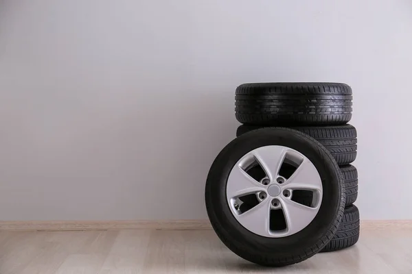 Neumáticos de coche cerca de pared ligera —  Fotos de Stock