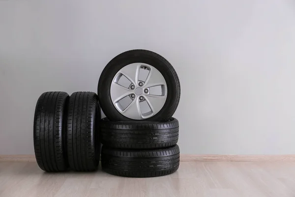 Neumáticos de coche cerca de pared ligera —  Fotos de Stock