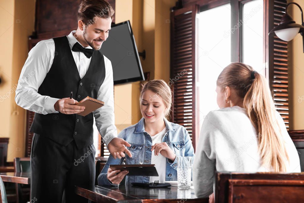 Waiter taking order in restaurant