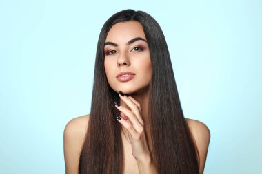 Renkli arka planda sağlıklı uzun saçlı güzel genç kadının portresi