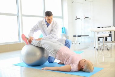 Rehabilitasyon merkezinde olgun hasta ile çalışan fizyoterapist