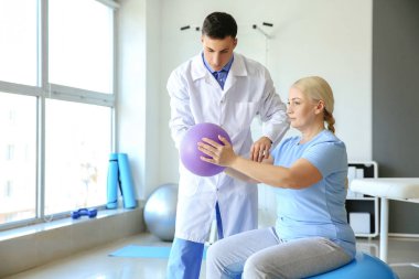 Rehabilitasyon merkezinde olgun hasta ile çalışan fizyoterapist