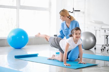 Rehabilitasyon merkezinde küçük kız ile çalışan fizyoterapist