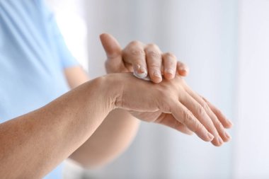 Olgun kadın evde el kremi uygulayarak, kapatmak