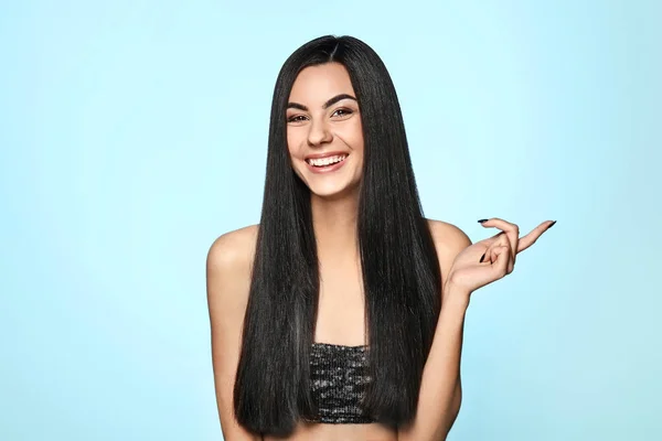 Portrait of beautiful young woman with healthy long hair on color background — Stock Photo, Image