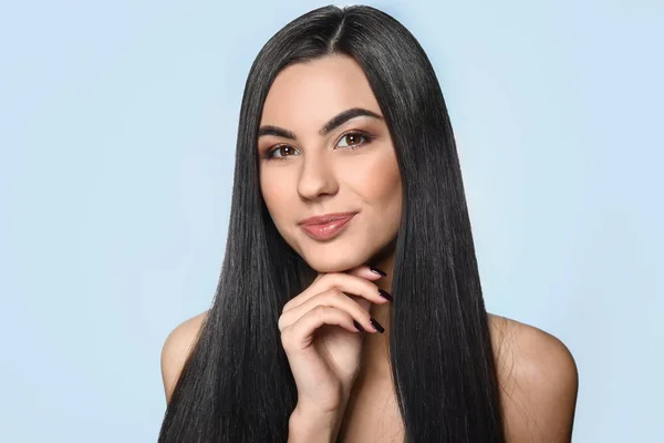 Portrait of beautiful young woman with healthy long hair on color background — Stock Photo, Image