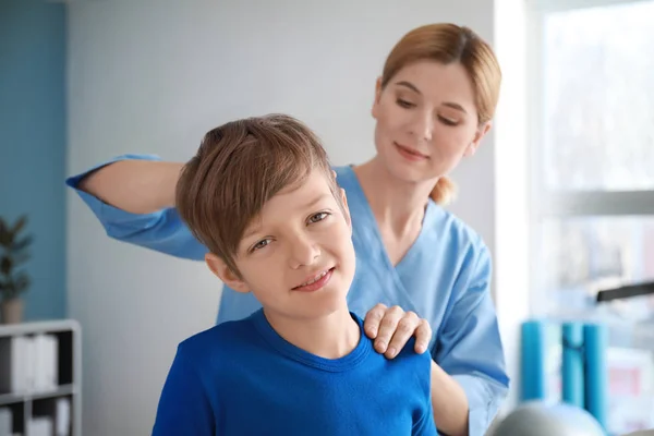 Physiothérapeute travaillant avec un petit garçon dans un centre de réadaptation — Photo