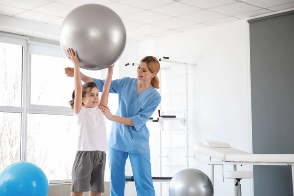 Physiotherapist working with little girl in rehabilitation center — Stock Photo, Image