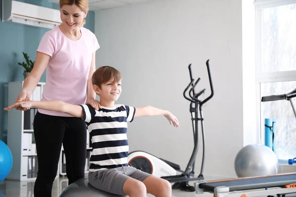 Physiotherapist working with little boy in rehabilitation center — Stock Photo, Image