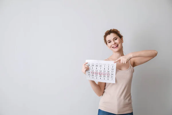 Šťastná žena s kalendářem na pozadí — Stock fotografie