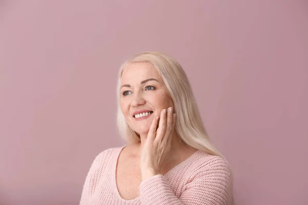 Mujer madura con piel sana sobre fondo de color —  Fotos de Stock