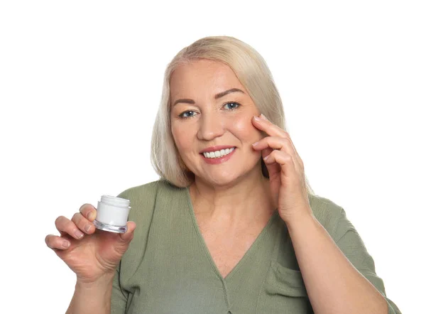 Érett nő alkalmazása arckrém, fehér háttér — Stock Fotó