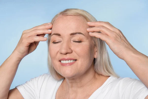 Mature woman with healthy skin on color background — Stock Photo, Image