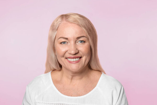 Зрелая женщина со здоровой кожей на цветном фоне

