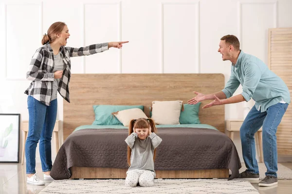 Sad little girl covering ears while her parents are arguing at home — Stock Photo, Image