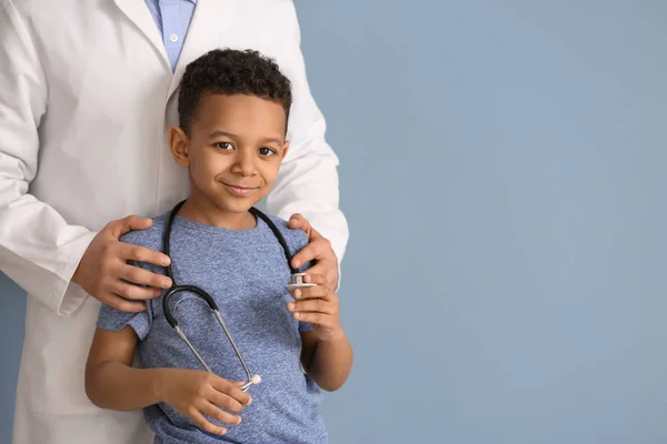 Kinderarzt und afrikanisch-amerikanischer Junge auf farbigem Hintergrund — Stockfoto