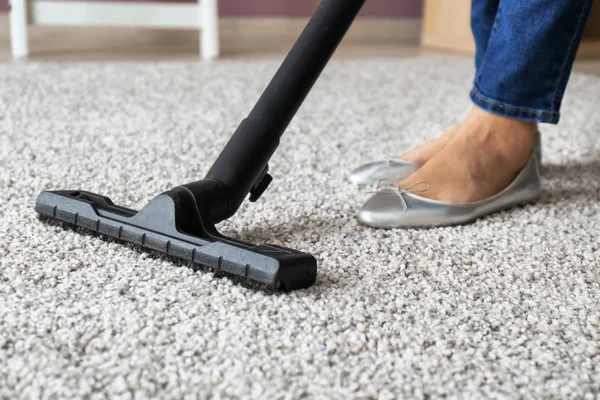 Woman hoovering carpet with vacuum cleaner — Stock Photo, Image