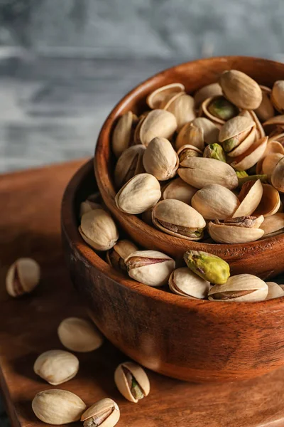 Bowls with tasty pistachio nuts on table, closeup — Stock Photo, Image