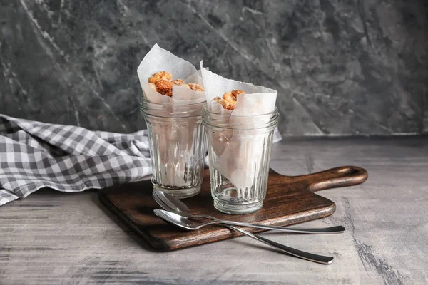 Jars with tasty sugared nuts on grey table — Stock Photo, Image