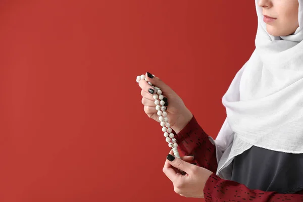Muslimische Frau mit Tasbih auf farbigem Hintergrund — Stockfoto