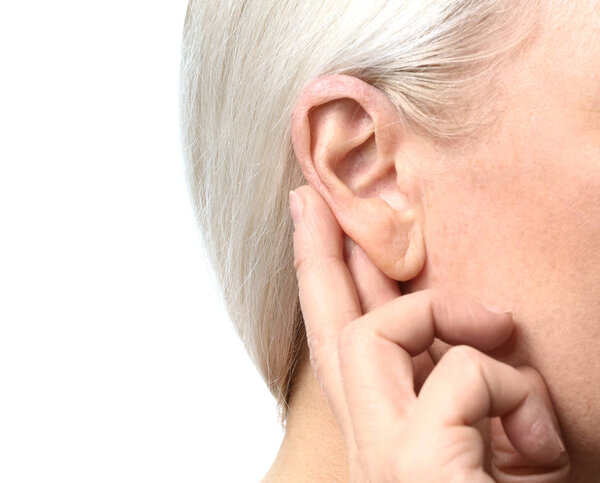 Зрелая женщина с проблемами со слухом на белом фоне, крупный план