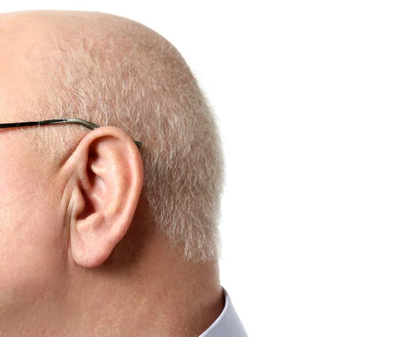 Старший мужчина с проблемами со слухом на белом фоне, крупный план — стоковое фото