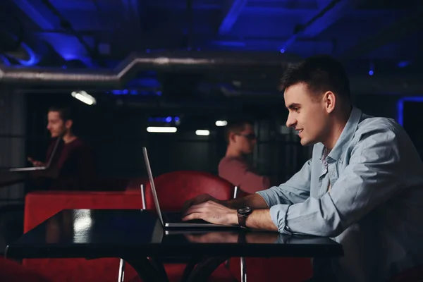 Ung man som arbetar på laptop i Café — Stockfoto