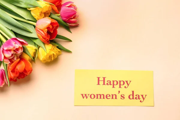 Tekst szczęśliwy dzień kobiet z pięknymi kwiatami na tle koloru — Zdjęcie stockowe