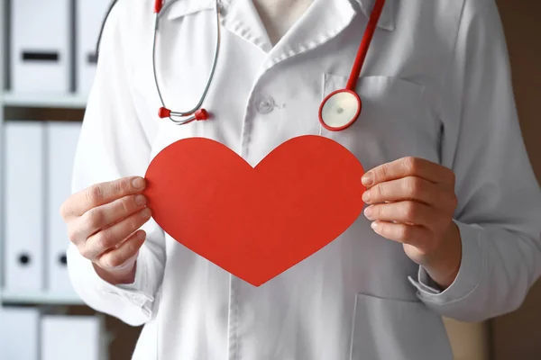 Female doctor with paper heart in clinic, closeup — Stock Photo, Image