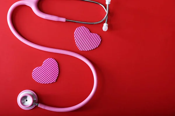 Stethoscope with hearts on color background — Stock Photo, Image