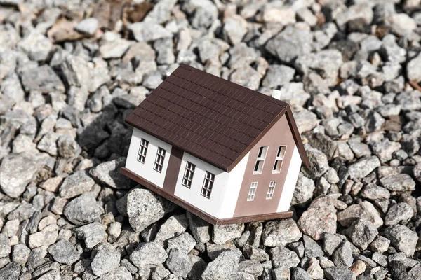 Modelo de casa sobre piedras al aire libre. Concepto de terremoto — Foto de Stock