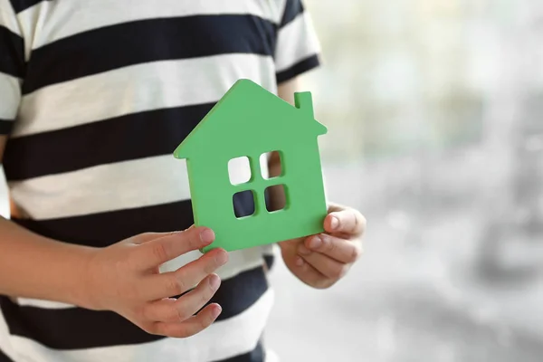 Niño pequeño con modelo de casa, primer plano. Concepto de terremoto — Foto de Stock