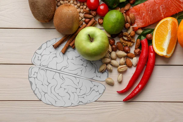 Людський мозок з різними корисними продуктами на білому дерев'яному фоні — стокове фото