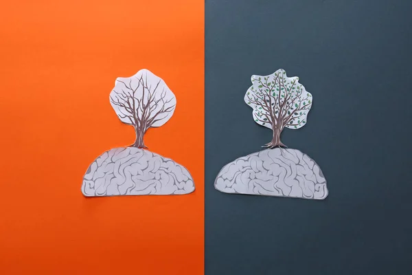 Hemispheres of brain with trees on color background. Concept of brain disorders