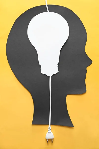 Menschenkopf mit Glühbirne und Stecker auf farbigem Hintergrund — Stockfoto