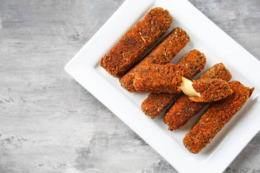 Gri masada lezzetli mozzarella çubukları ile plaka