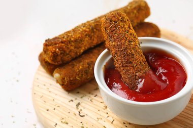 Ahşap tahta üzerinde sos ile lezzetli mozzarella çubukları, çekim