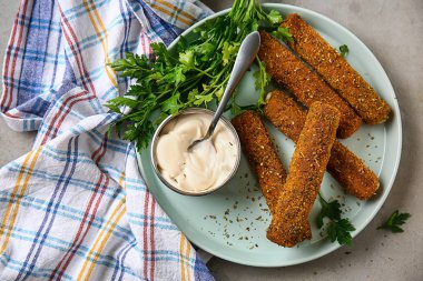 Gri masada lezzetli mozzarella çubukları ve sos ile plaka