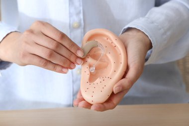 İşitme cihazı ve kulak modeli ile kadın doktor, çekim