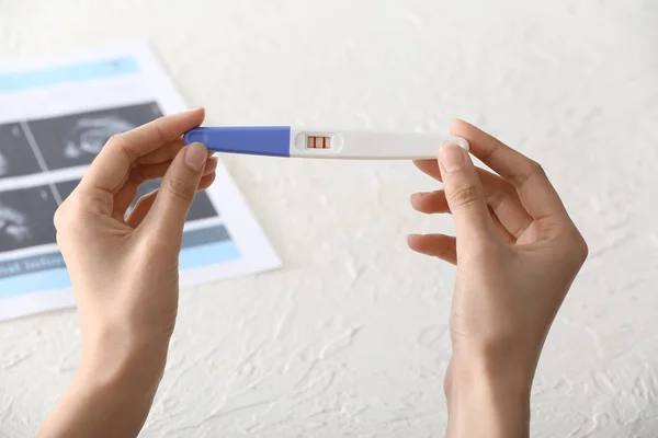 Ženská ruka s těhotenskou zkouškou — Stock fotografie