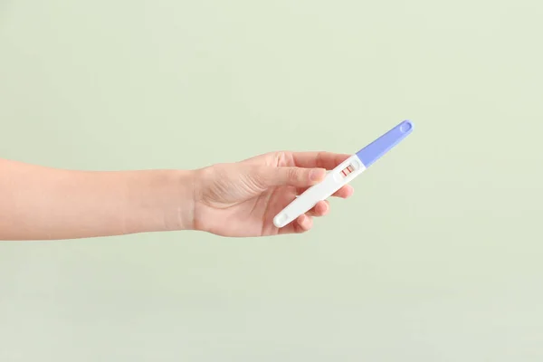 女性手与怀孕测试在颜色背景 — 图库照片