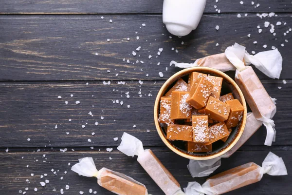 Tigela com doces salgados saborosos na mesa de madeira — Fotografia de Stock