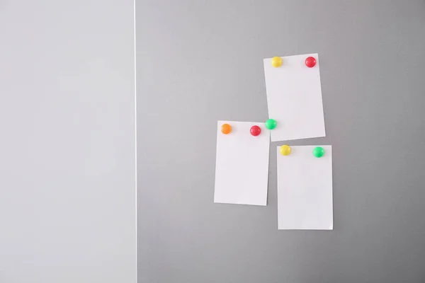 Папери з магнітами на дверях холодильника — стокове фото