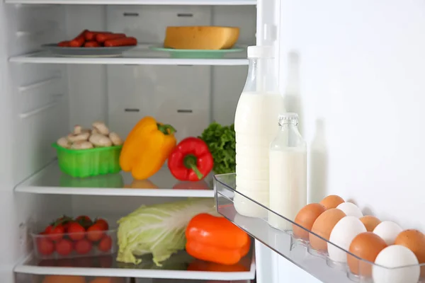 Telur dan susu di kulkas terbuka — Stok Foto