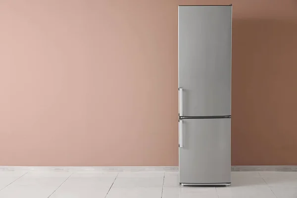 Modern fridge near color wall — Stock Photo, Image